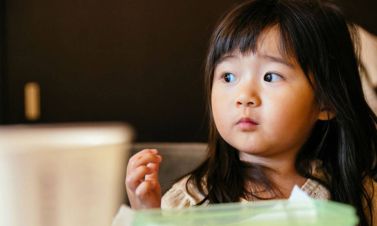 A young Asian girl looks to her right.