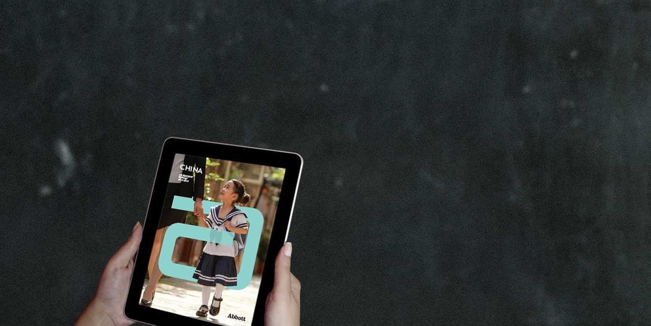 Hands hold a tablet with a picture of a young girl jumping rope with the Abbott "a" overlayed on the image.