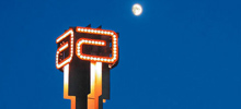 The Abbott Tower in Abbott Park, Illinois against a dark blue sky and bright moon.